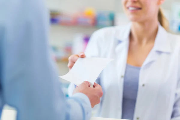 Cliente dando prescrição ao farmacêutico — Fotografia de Stock