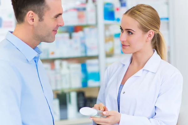 Farmacêutico e cliente na farmácia — Fotografia de Stock