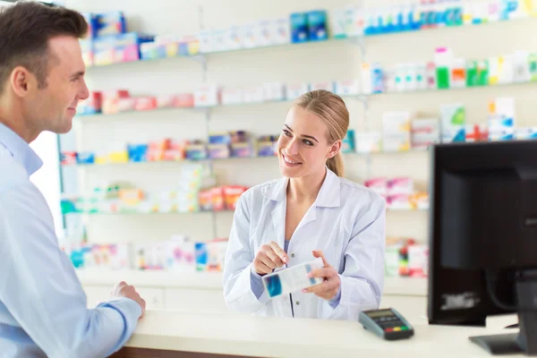 Farmacêutico e cliente na farmácia — Fotografia de Stock