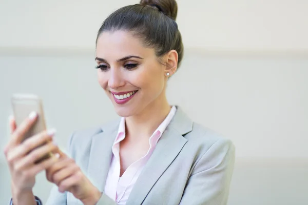 Jonge zakenvrouw gebruikend haar smartphone — Stockfoto