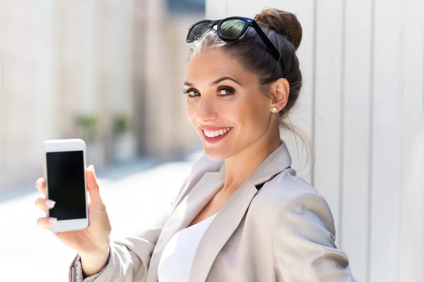 Jonge zakenvrouw gebruikend haar smartphone — Stockfoto