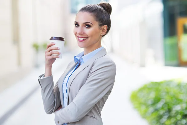 Businesswoman holding coffee outdoors — Stock Photo, Image