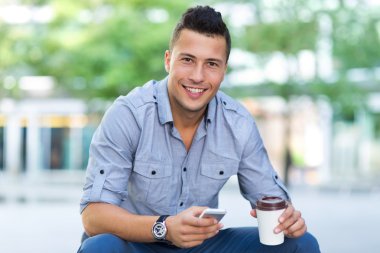 Smartphone açık havada olan genç adam