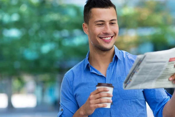 Homem segurando jornal e café — Fotografia de Stock