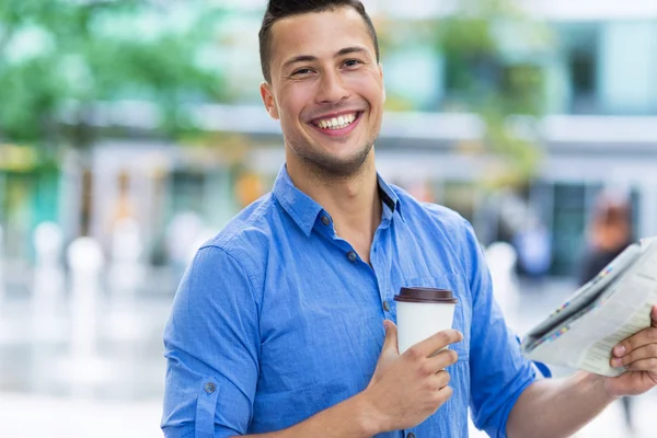 Mann hält Zeitung und Kaffee in der Hand — Stockfoto