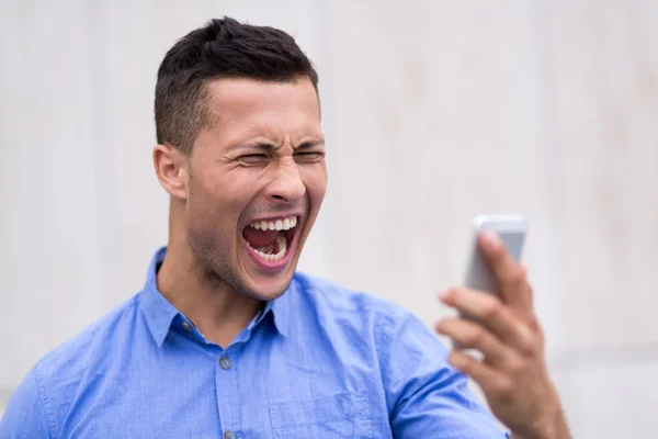 Человек кричит на мобильный телефон — стоковое фото