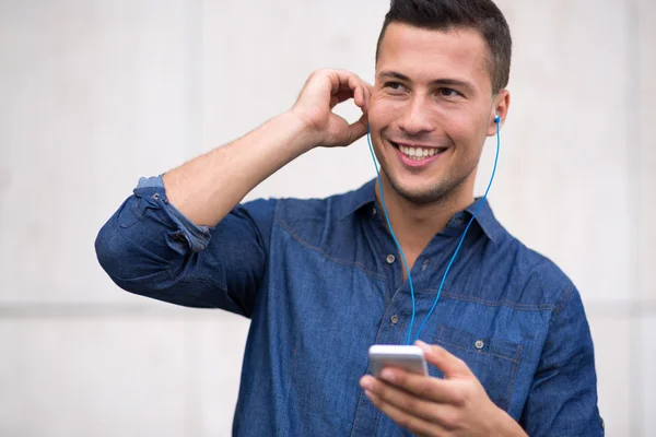 Человек слушает музыку на мобильном телефоне — стоковое фото