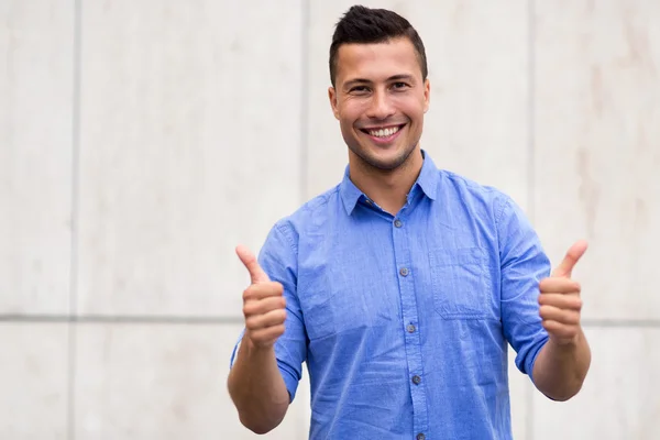 Joven mostrando pulgares hacia arriba — Foto de Stock