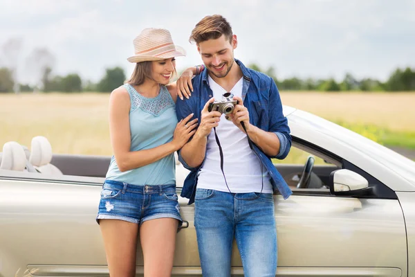 Casal tirando fotos enquanto fora em uma viagem de carro — Fotografia de Stock