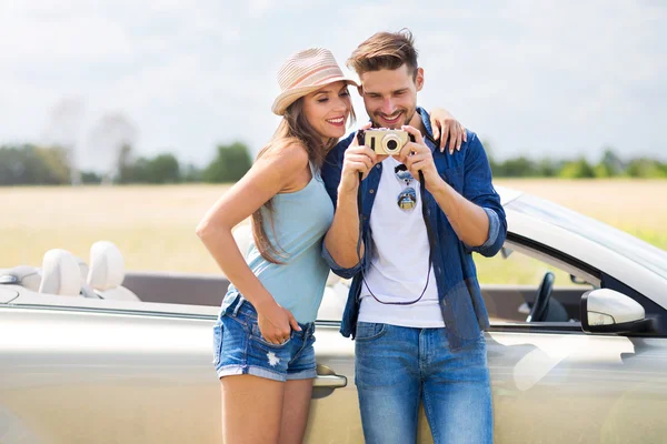 Casal tirando fotos enquanto fora em uma viagem de carro — Fotografia de Stock