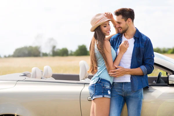 Jeune couple debout près de convertible — Photo