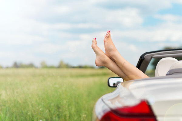 Feet hanging out of convertible