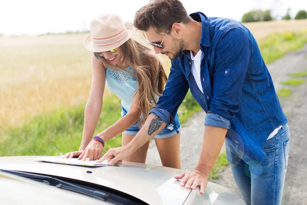 Couple lisant une carte debout près de convertible — Photo