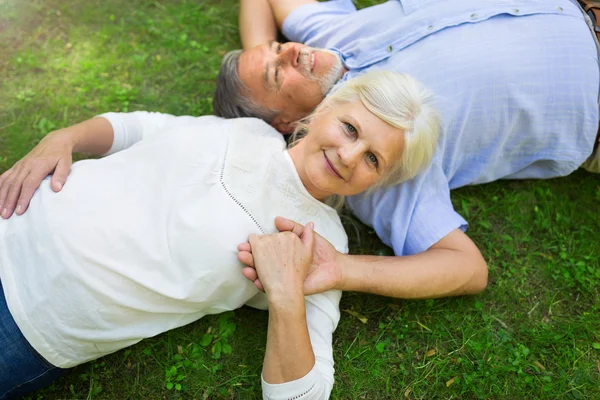 Seniorenpaar liegt im Gras — Stockfoto