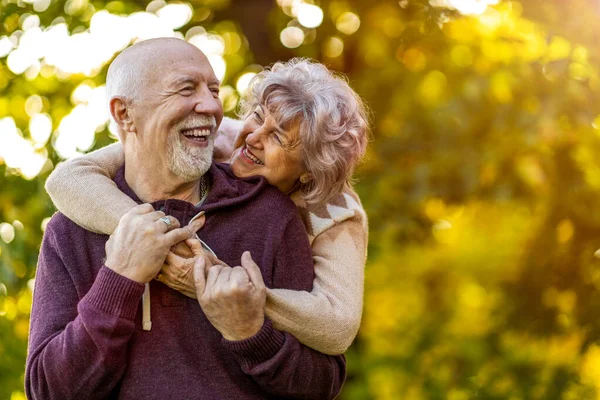 秋の美しい都市公園で一緒に過ごす幸せな高齢者のカップル — ストック写真