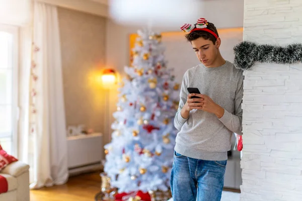 Genç Çocuk Noel Zamanı Evde Cep Telefonu Kullanıyor — Stok fotoğraf
