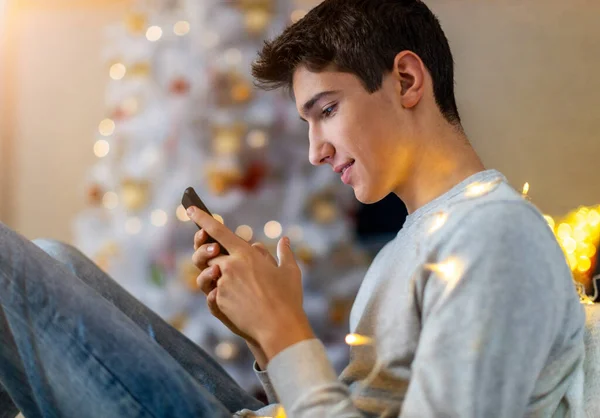 Ragazzo Adolescente Che Utilizza Telefono Cellulare Casa Nel Periodo Natalizio — Foto Stock