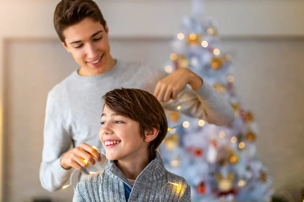 Két Testvér Játszik Karácsonyi Fényekkel Otthon — Stock Fotó