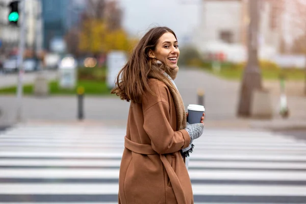 Młoda Kobieta Spaceruje Ulicą Trzymając Filiżankę Kawy — Zdjęcie stockowe