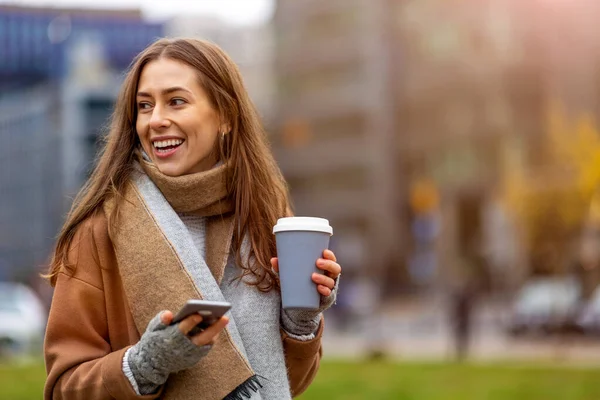 Mujer Joven Sonriente Con Teléfono Inteligente Taza Café Aire Libre — Foto de Stock