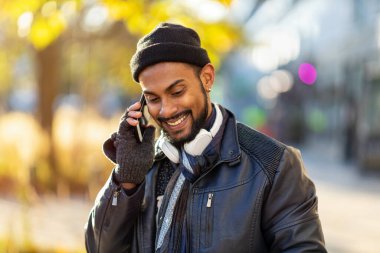 Sokakta cep telefonu kullanan yakışıklı bir gencin portresi.