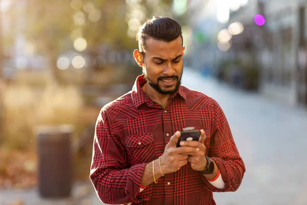 Egy Jóképű Fiatalember Portréja Aki Mobiltelefont Használ Utcán — Stock Fotó