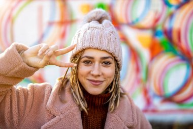 Dışarıda örülmüş saçları olan neşeli genç bir kadın.