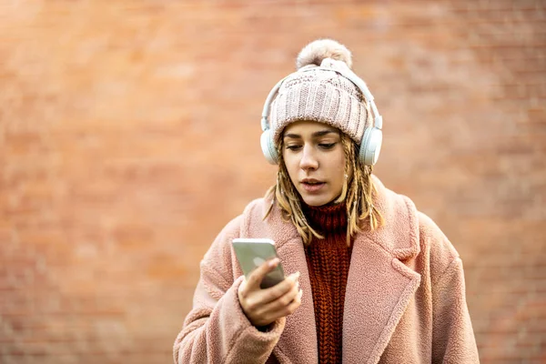 Glückliche Junge Frau Mit Kopfhörer Und Handy lizenzfreie Stockfotos