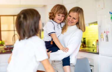 Anne ve oğulları mutfakta.