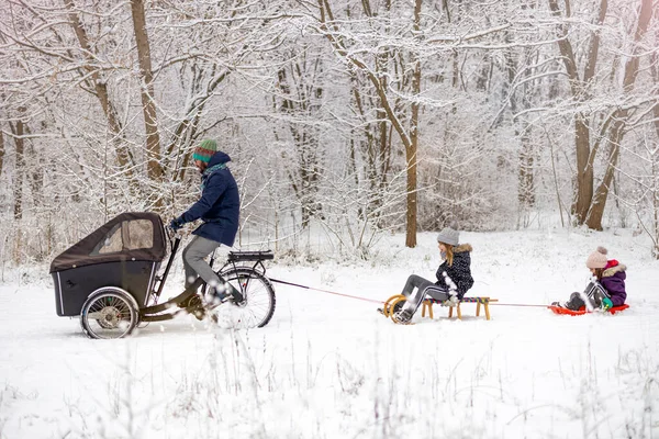Kargo Bisikletli Bir Adam Kışın Çocukları Kızakla Taşıyor Stok Fotoğraf