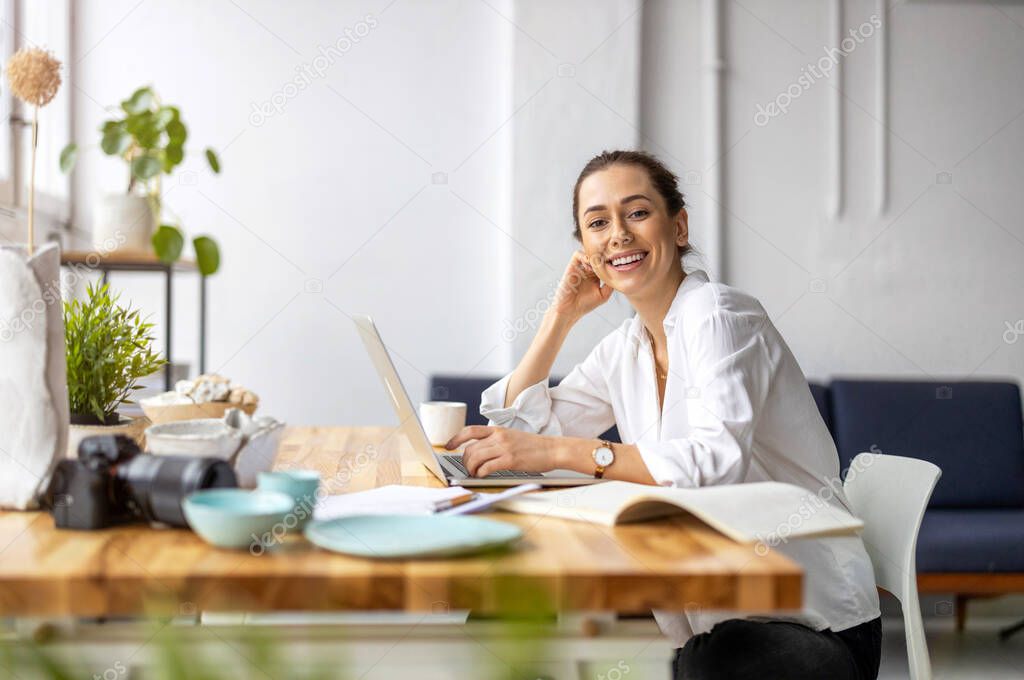 Creative young woman working on laptop in her studio