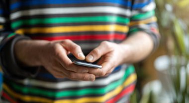 Akıllı telefonda yazan erkek eller.