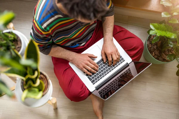 Junger Mann Der Hause Mit Laptop Arbeitet Sitzt Auf Dem Stockfoto