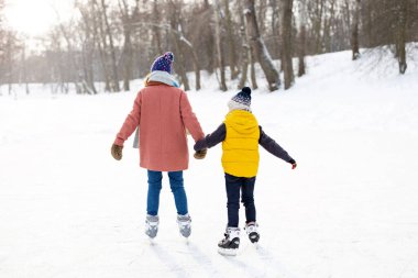 Anne ve oğlu buz pateni yapıyor.