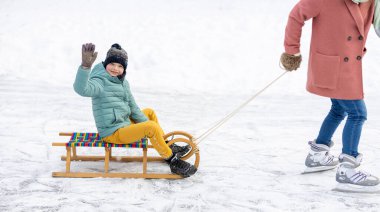Anne ve oğlu karda oynayarak harika bir kış günü geçiriyorlar.