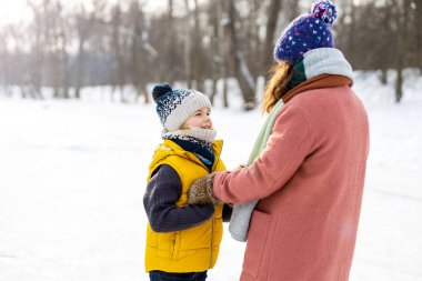 Anne ve oğlu karda oynayarak harika bir kış günü geçiriyorlar.