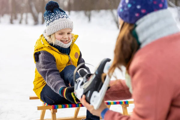 Moeder Helpt Zoon Zijn Schaatsen Aan Trekken Stockfoto