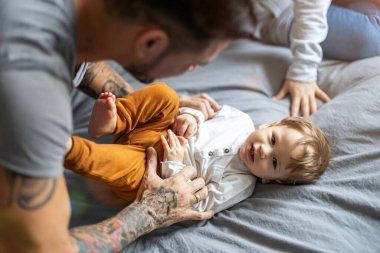 Baba ve oğul evde birlikte eğleniyorlar.