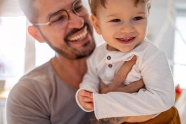 Baba ve oğul evde birlikte eğleniyorlar.