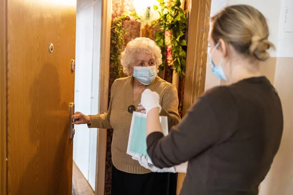 Female Volunteer Delivering Bags Shopping Elderly Woman Coronavirus Pandemic — Fotografia de Stock