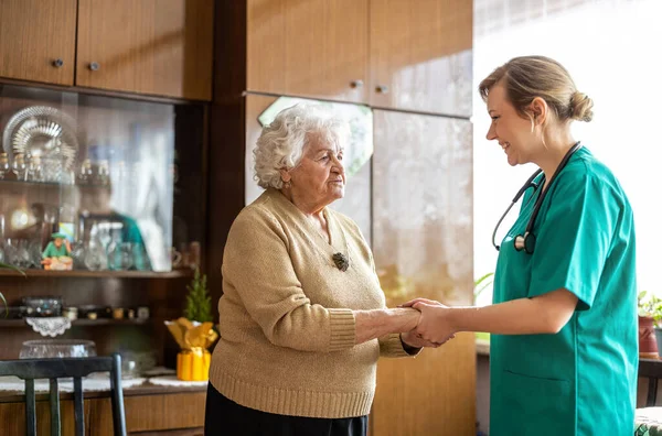 Freundliche Krankenschwester Unterstützt Eine Ältere Dame Stockfoto