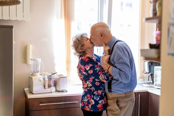 Ευτυχισμένο Ζευγάρι Ηλικιωμένων Που Φιλιούνται Στην Κουζίνα — Φωτογραφία Αρχείου