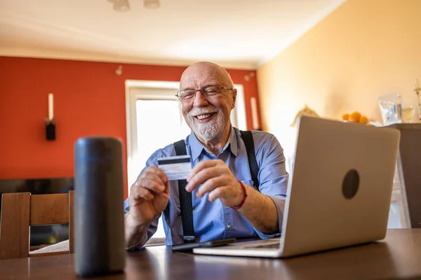 Senior man using Virtual Assistant at home