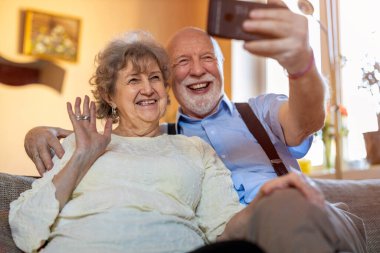 Video araması için cep telefonu kullanan mutlu yaşlı çift 