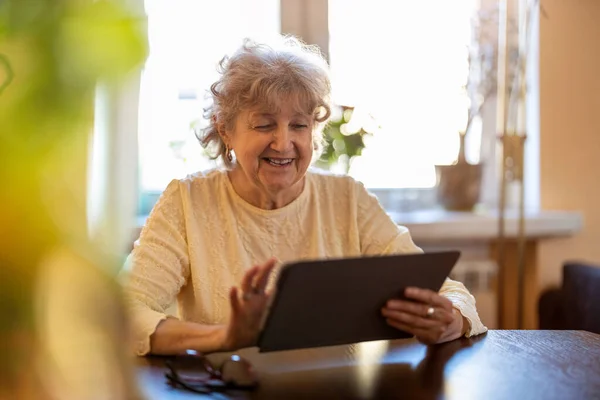 Evde Dijital Tablet Kullanan Mutlu Yaşlı Kadın — Stok fotoğraf