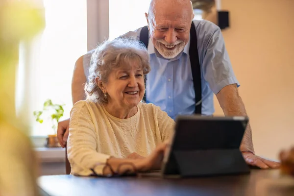 Feliz Pareja Ancianos Usando Tableta Digital Casa Imágenes de stock libres de derechos