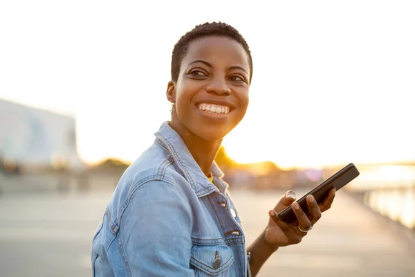 Açık Havada Akıllı Telefon Kullanan Gülümseyen Genç Bir Kadın — Stok fotoğraf