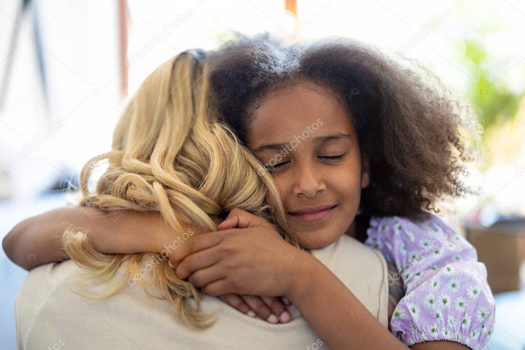 Mother and daughter hugging at home