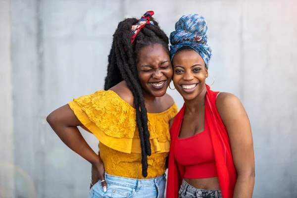 Duas Amigas Sorrindo Frente Uma Parede Cinza — Fotografia de Stock