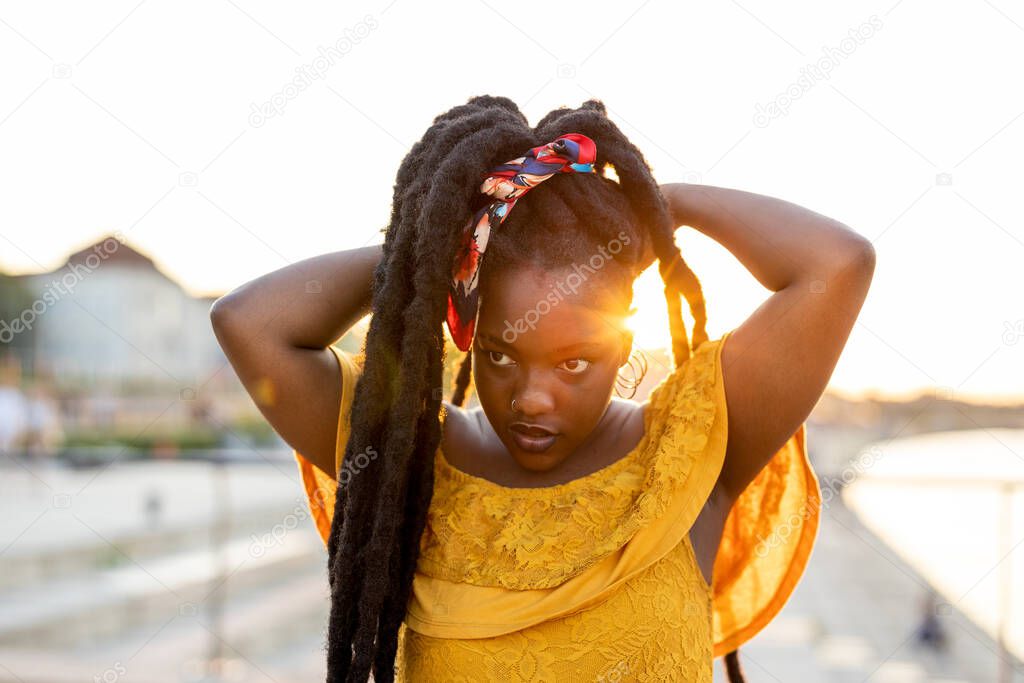 Happy young woman with dreadlocks outdoors